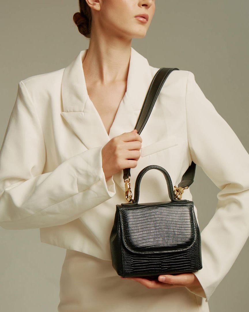 Model holding the FLORENCE Lizard Black bag with its shoulder strap