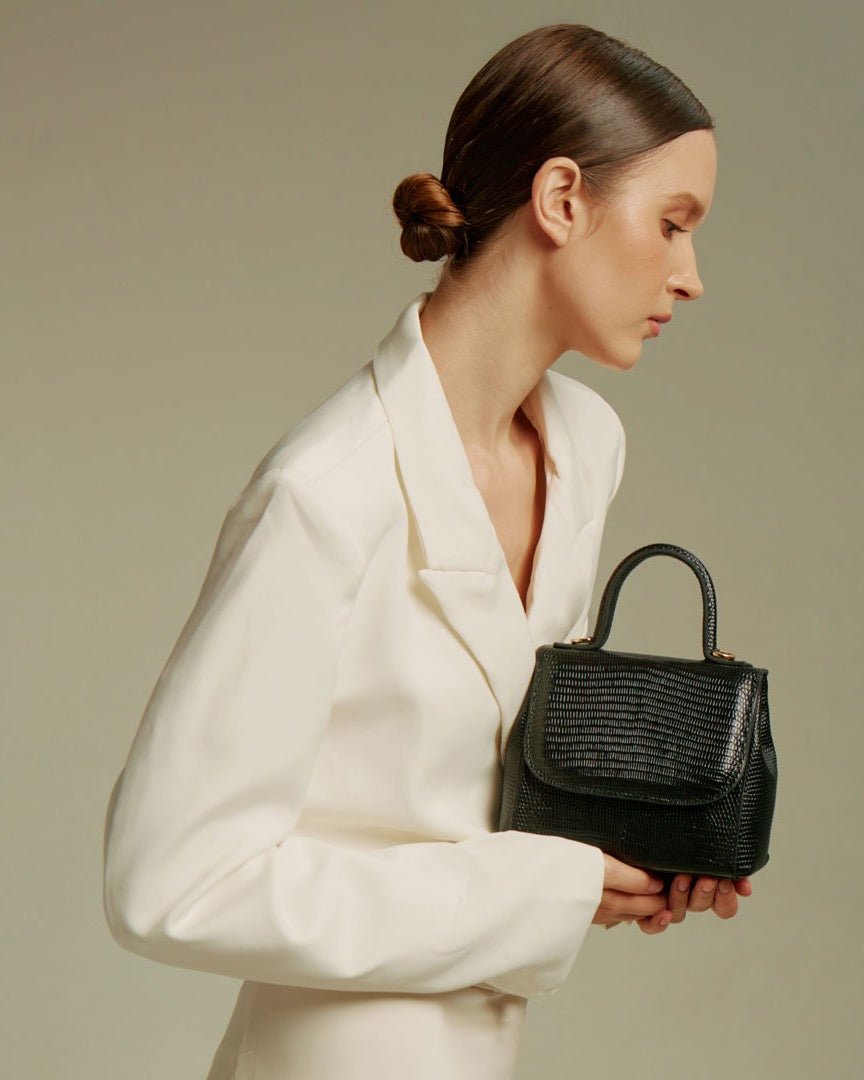 Model carrying the FLORENCE Lizard Black bag by its top handle