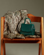 FLORENCE Lizard Dark Green bag on a wooden chair